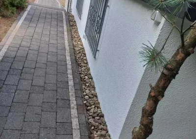 Frischer Gehweg an einem Mehrfamilienhaus gesetzt